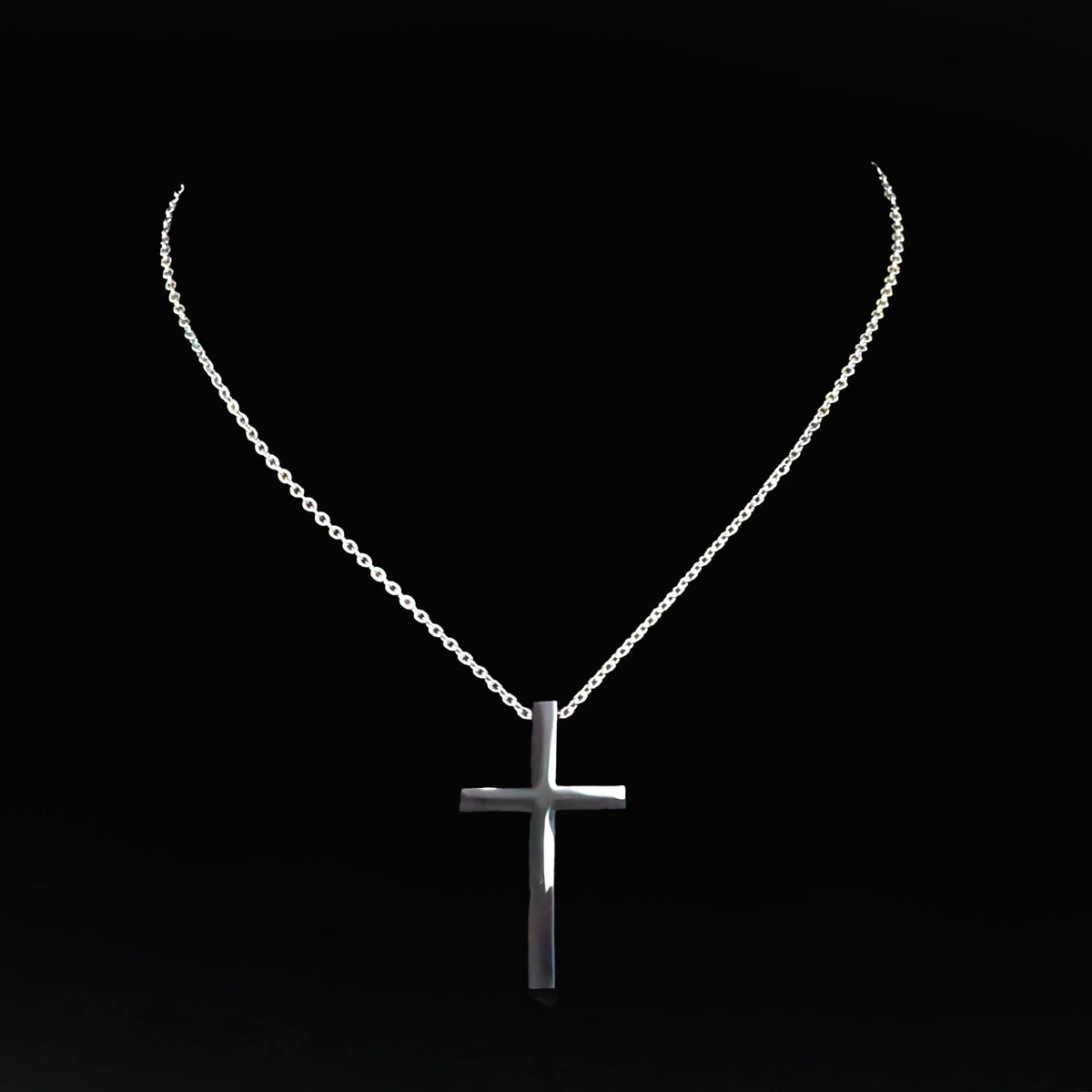 Silver cross pendant on a delicate chain necklace.