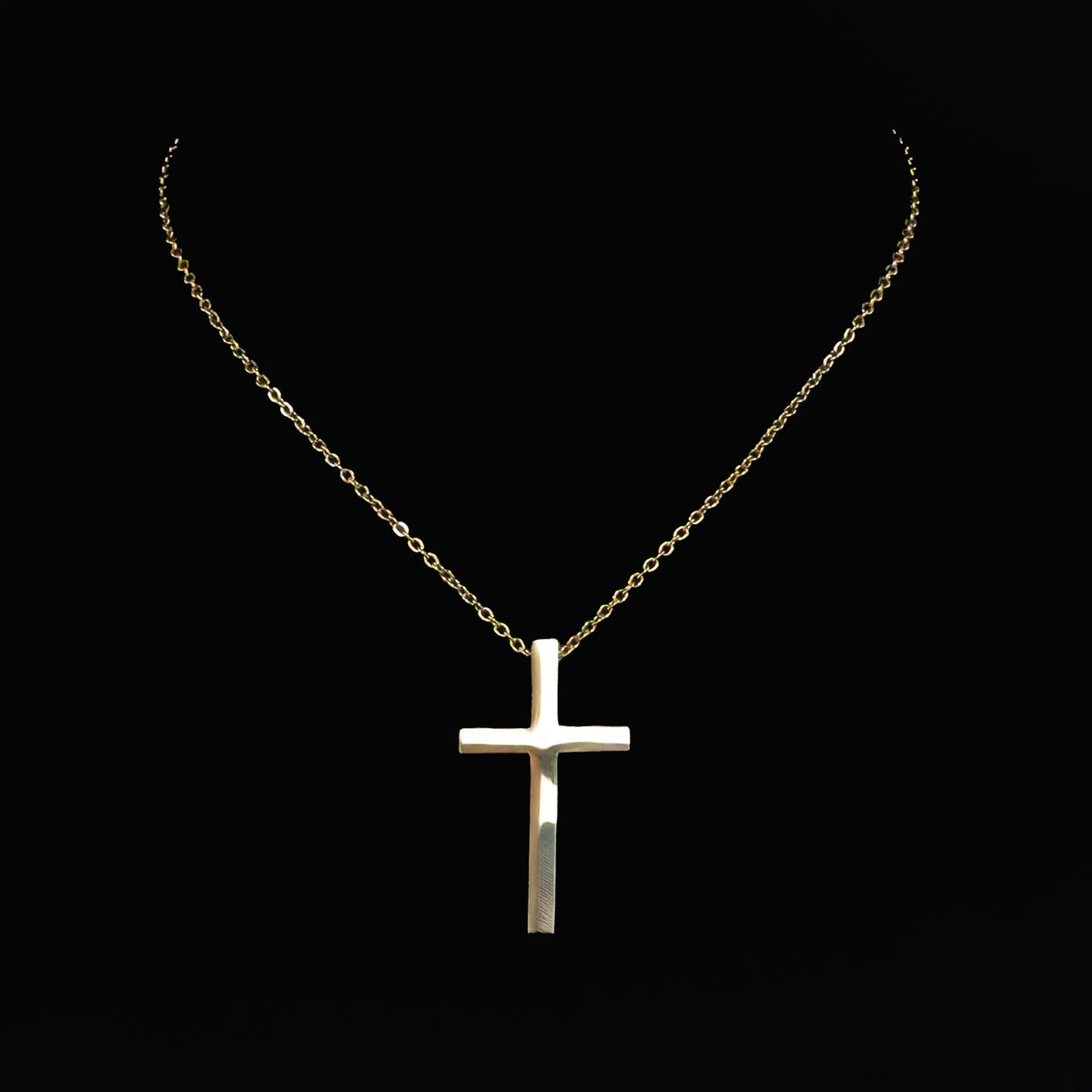 Silver cross pendant on a delicate chain necklace.
