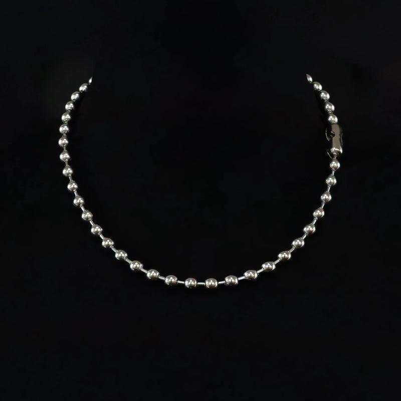 Silver beaded necklace or chain with a clasp visible on one end.