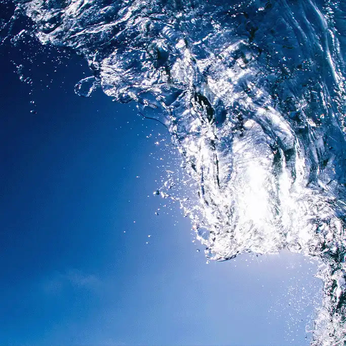 A crashing ocean wave with splashing water droplets.