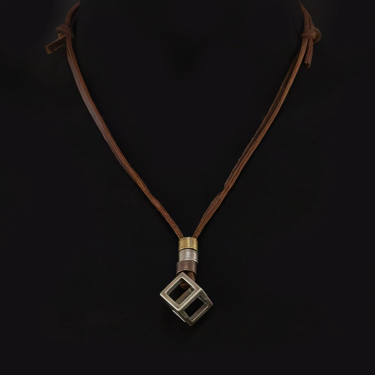 Necklace with a square-shaped pendant on a leather cord.