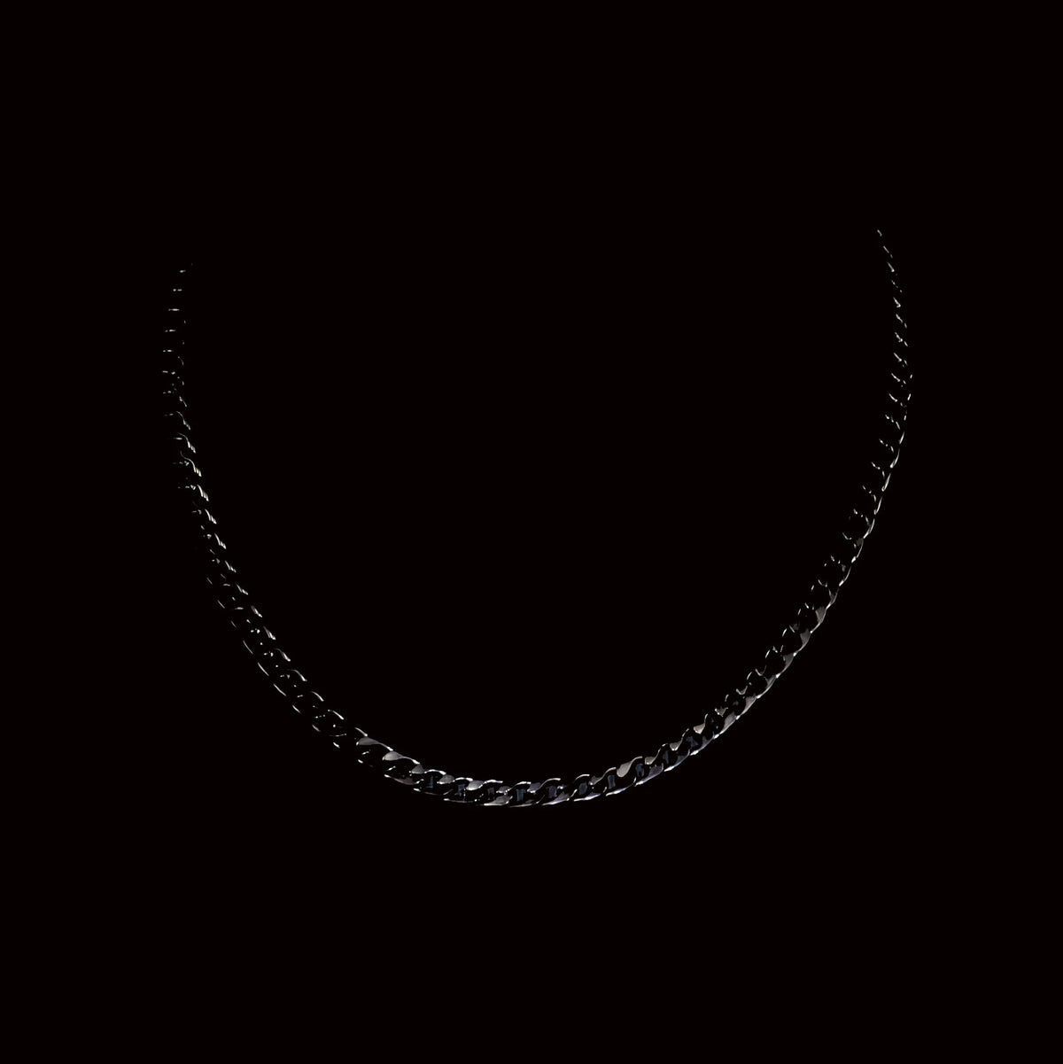 Black metal chain necklace against a dark background.