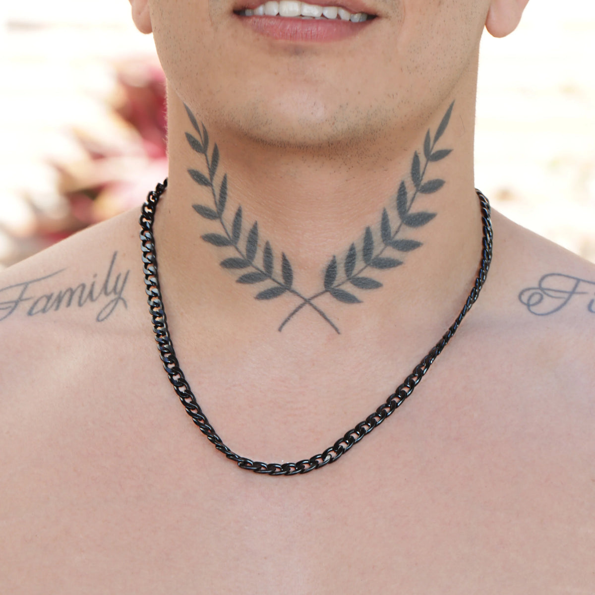 Tattoo of crossed olive branches on a person’s neck.