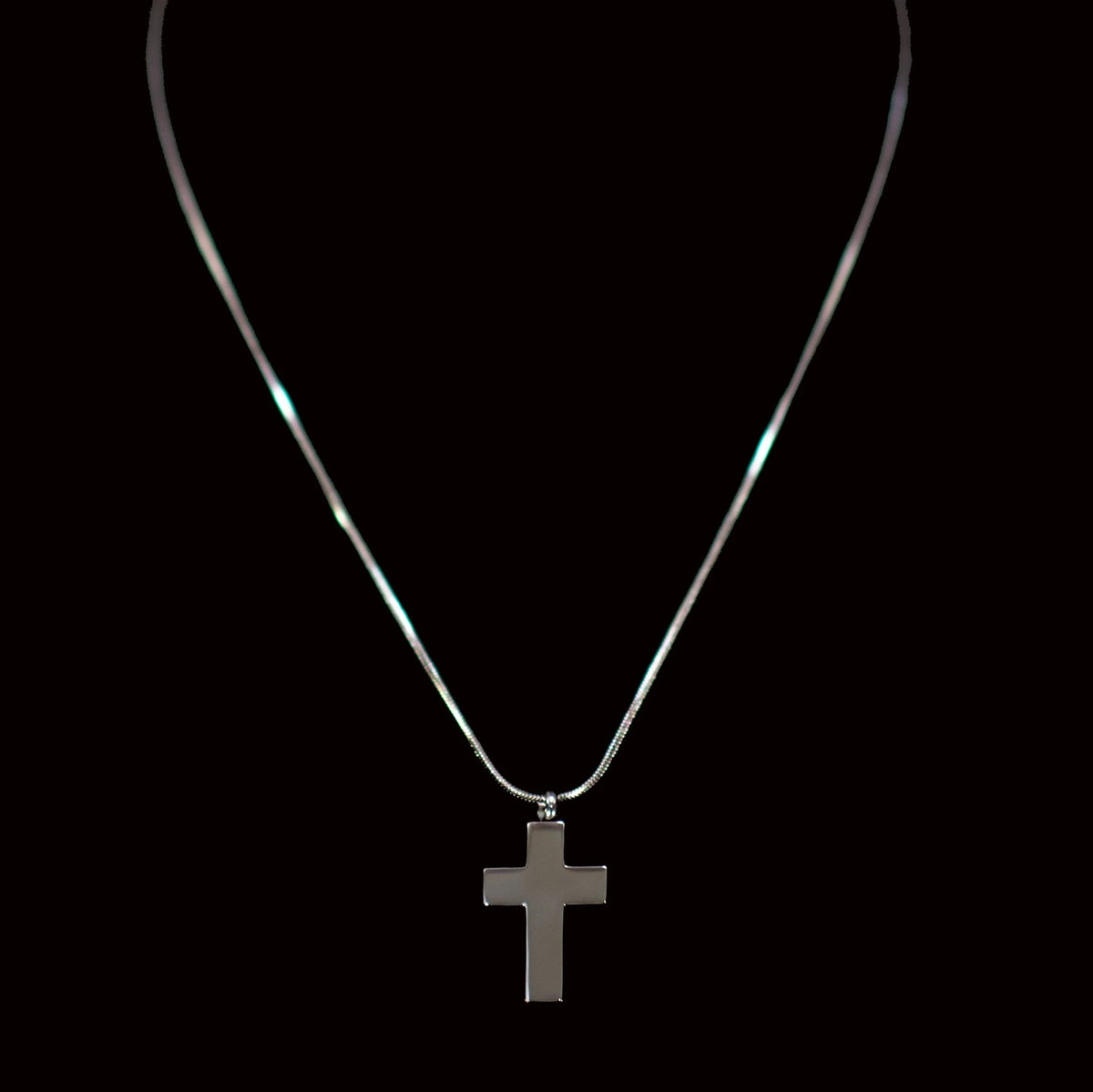 Silver chain necklace with a cross pendant.