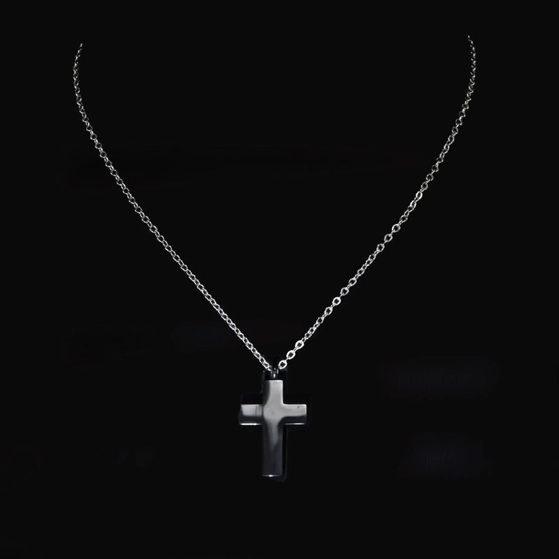 Silver cross pendant on a delicate chain necklace.