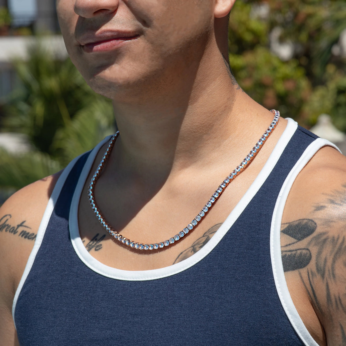 Diamond tennis necklace worn over a navy and white tank top.