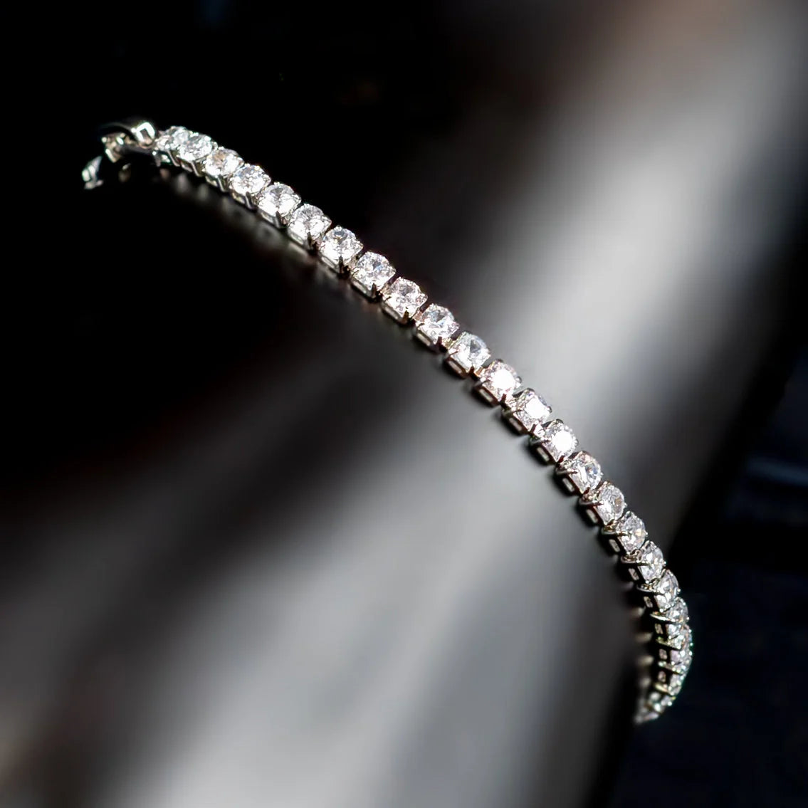 Diamond tennis bracelet with a curved line of sparkling stones.