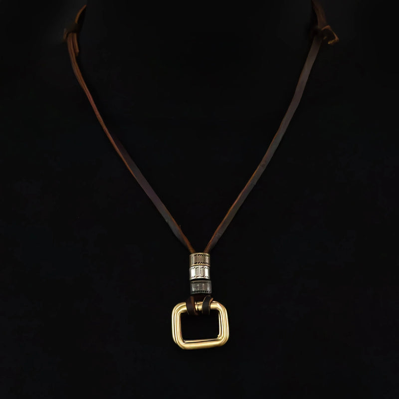 Necklace with a gold square pendant on a dark leather cord.