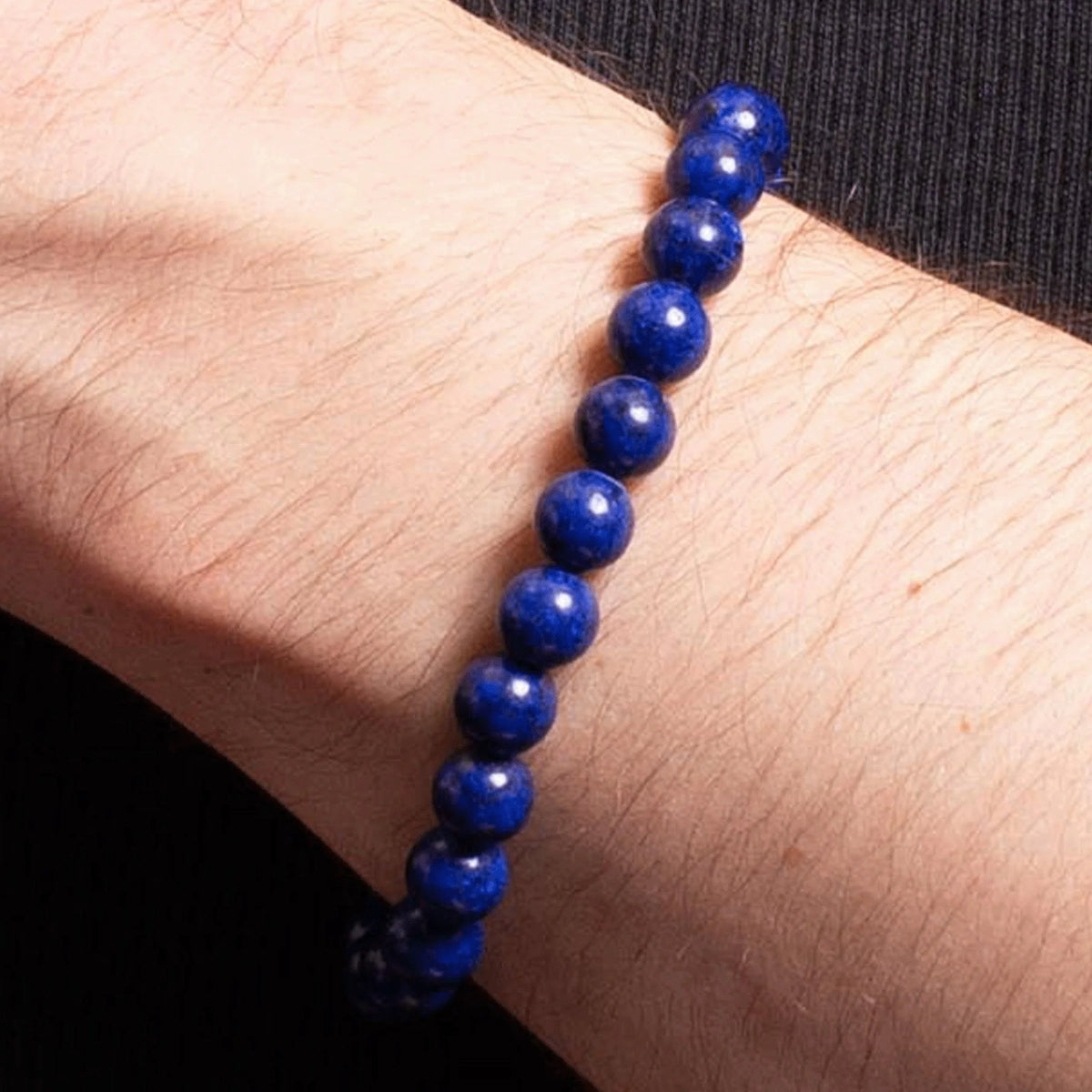 Blue beaded bracelet worn on a wrist.