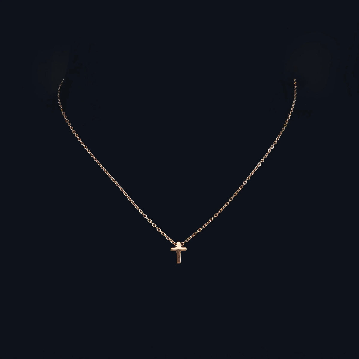 Delicate silver necklace with a small cross pendant.