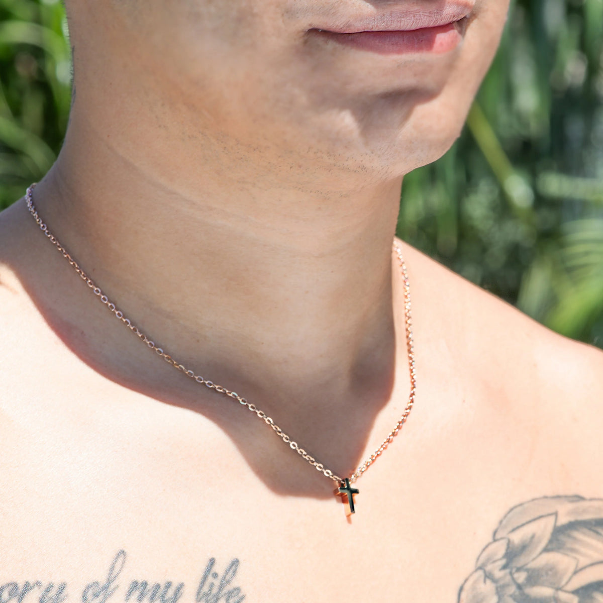 Silver necklace with a small cross pendant.