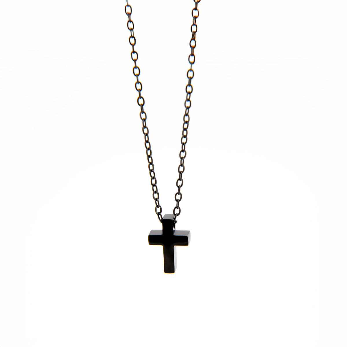 Black cross pendant on a metal chain necklace.