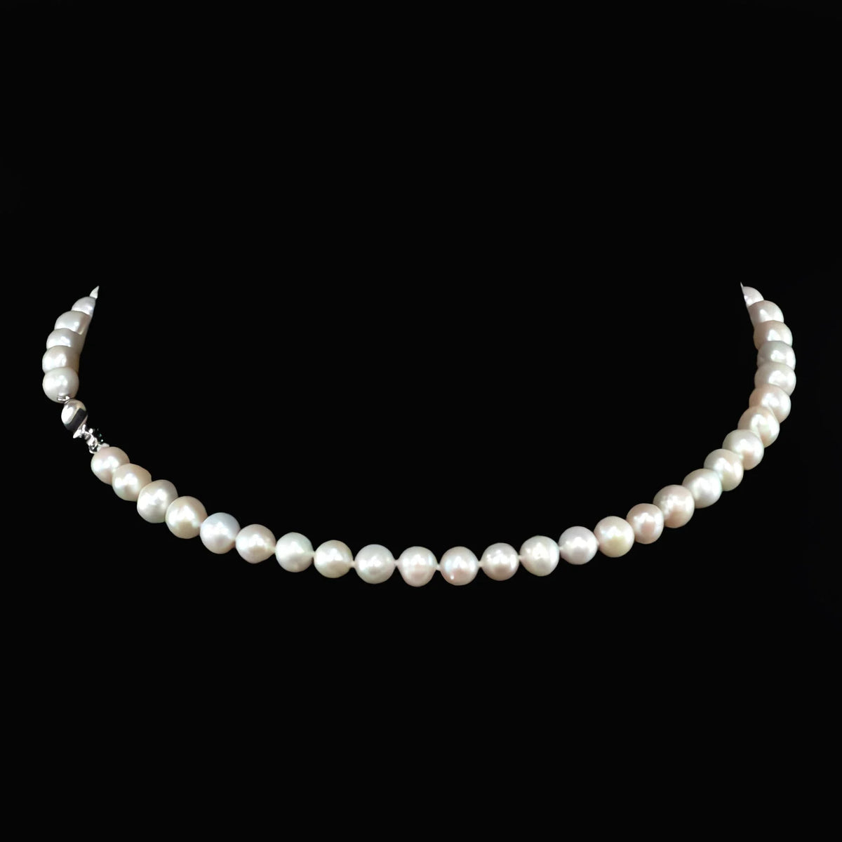 Pearl necklace with round, lustrous white pearls strung in a single strand.