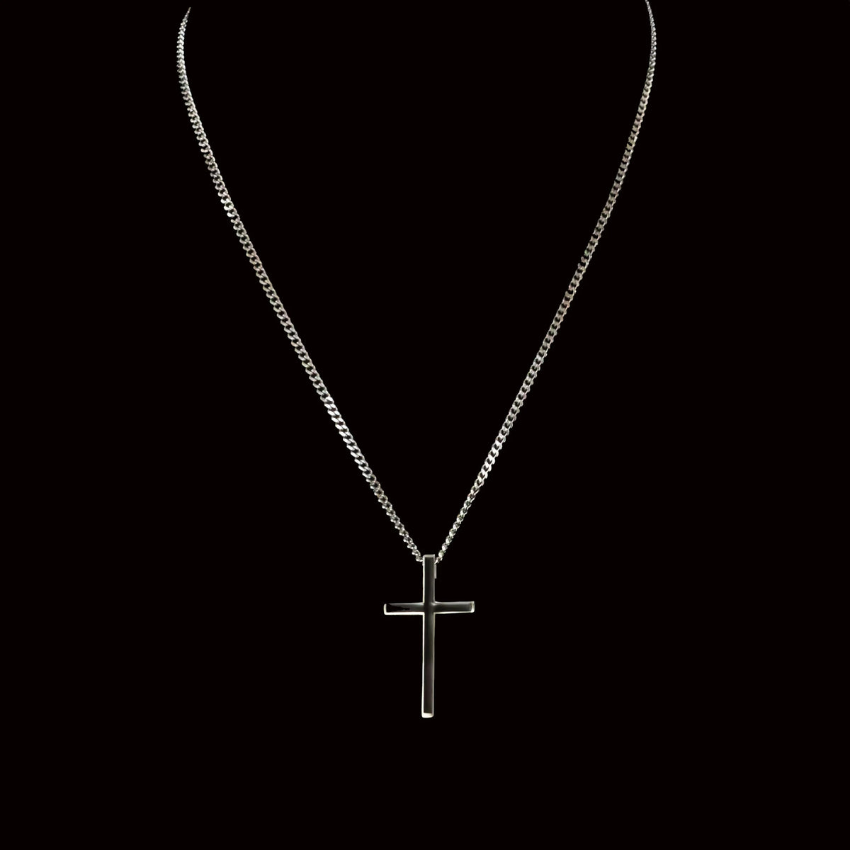 Silver cross pendant on a delicate chain necklace.