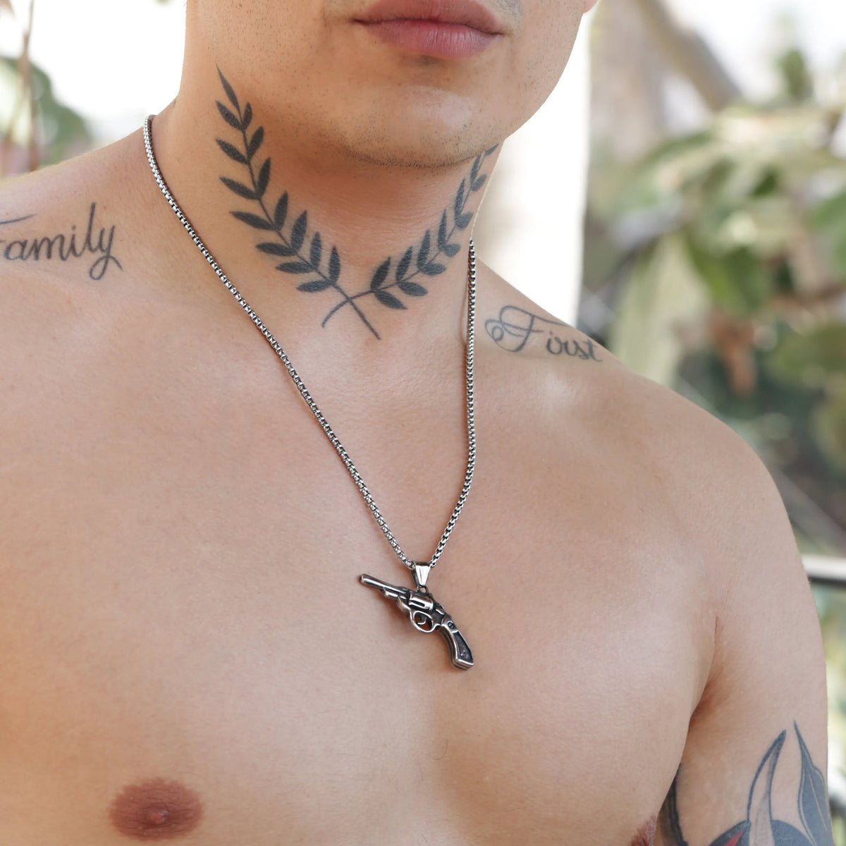 Silver necklace with a pistol-shaped pendant.