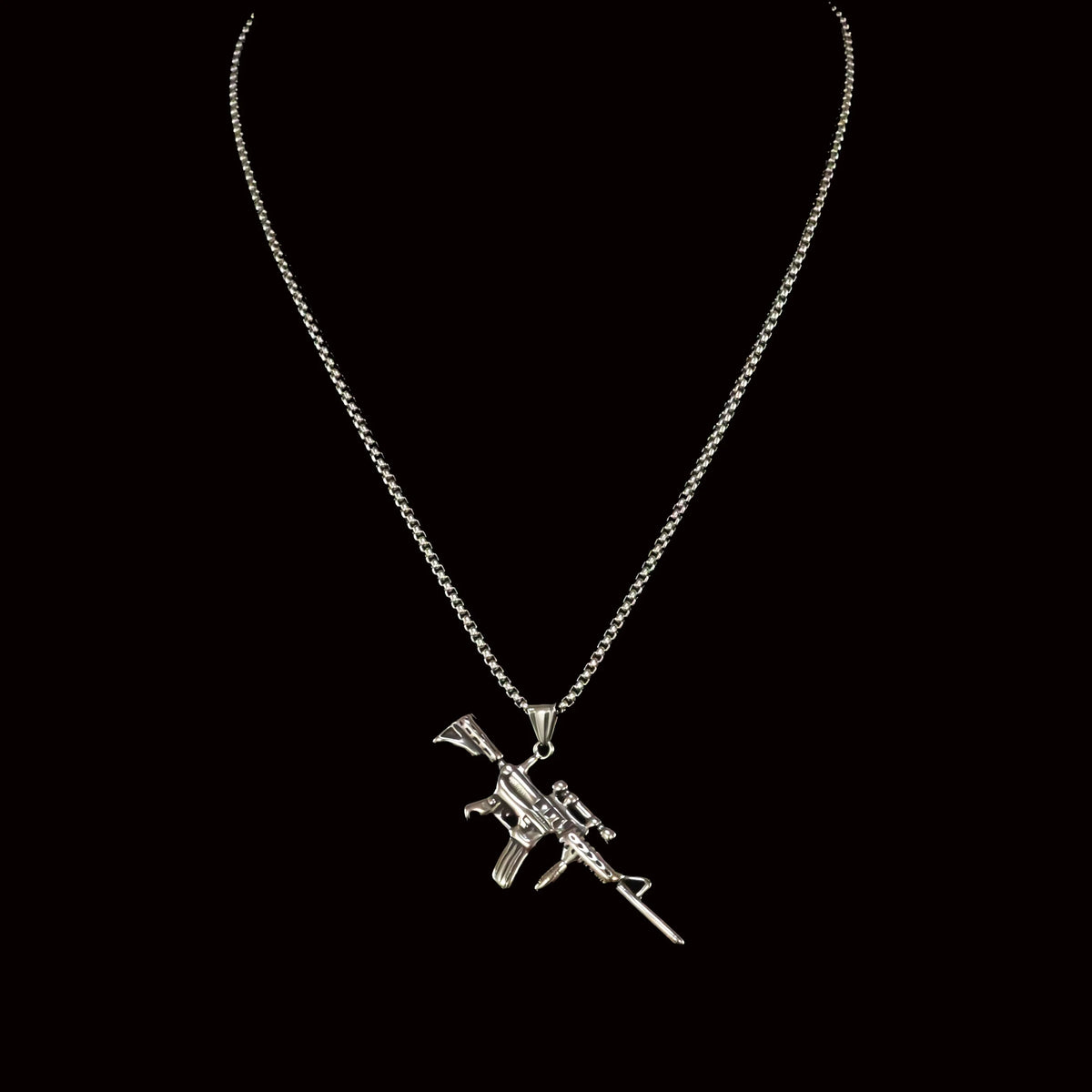 Silver necklace with an assault rifle pendant.