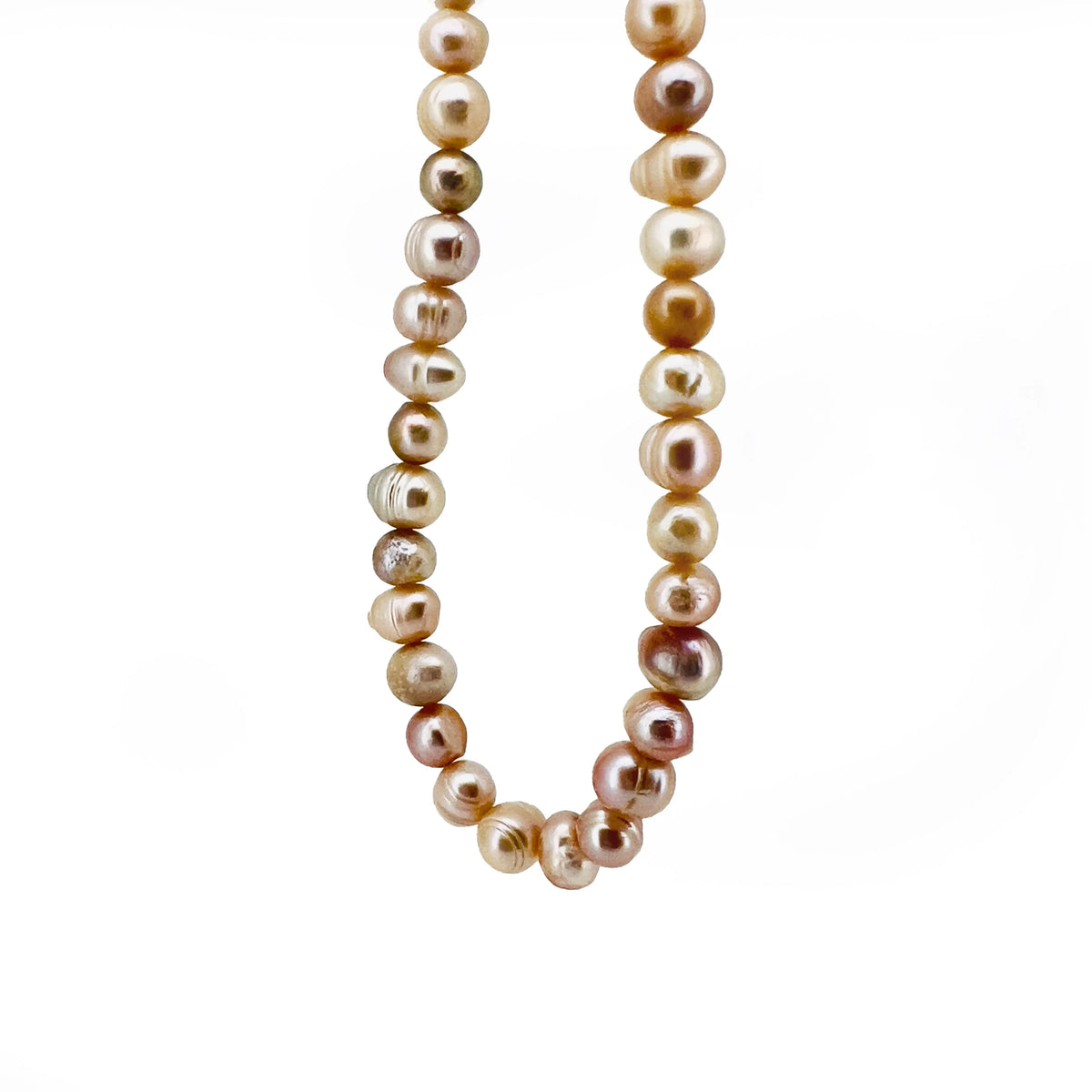 String of irregularly shaped pearls in various shades of cream, gold, and pink.