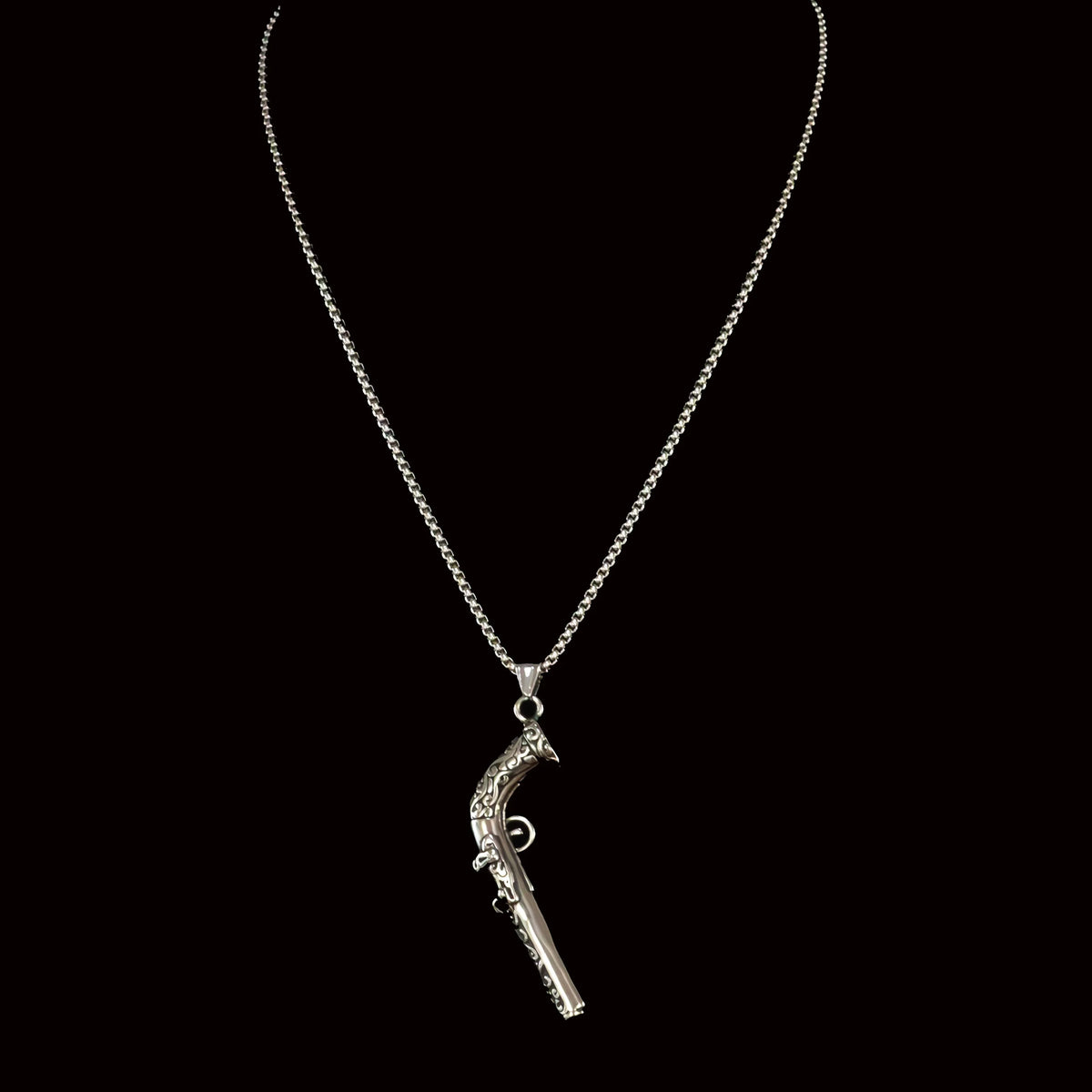 Silver necklace with a pistol-shaped pendant.