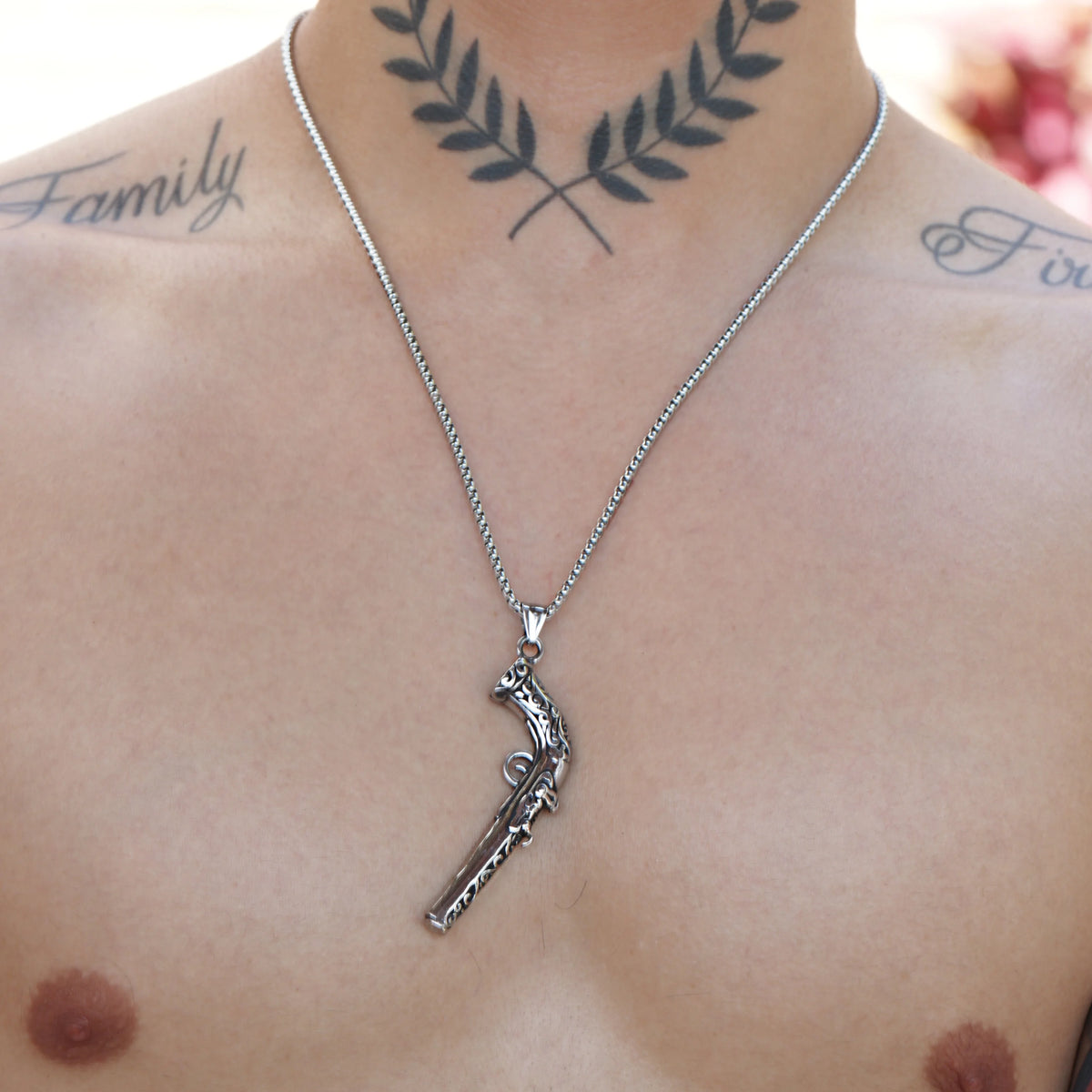 Silver necklace with a pistol-shaped pendant.