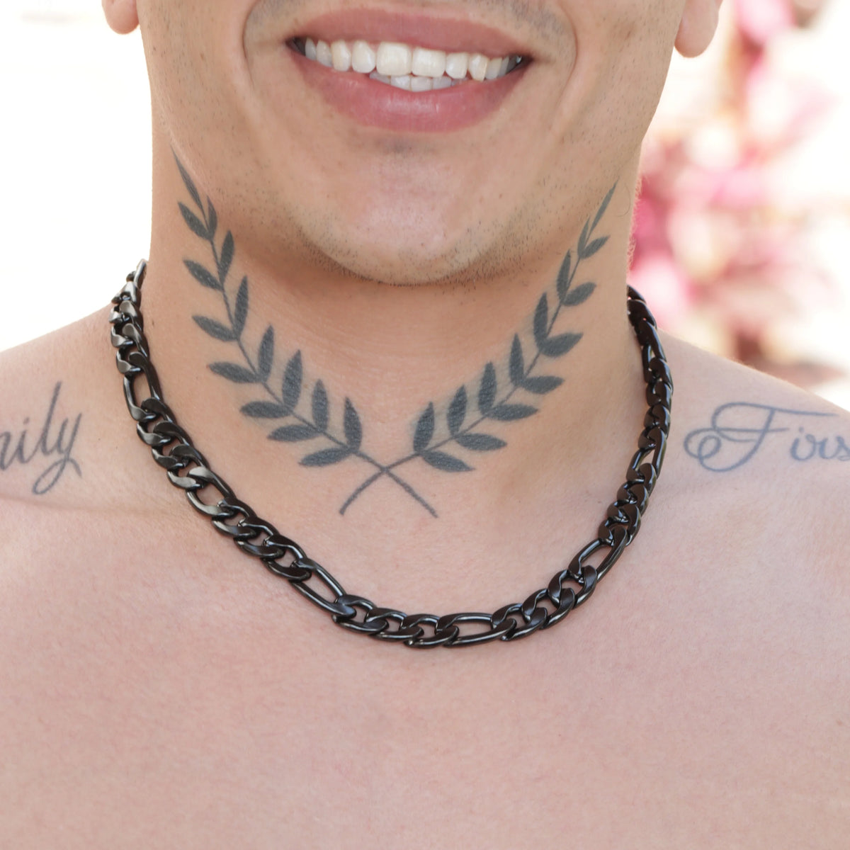 Tattoo of symmetrical olive branches on a person’s neck.