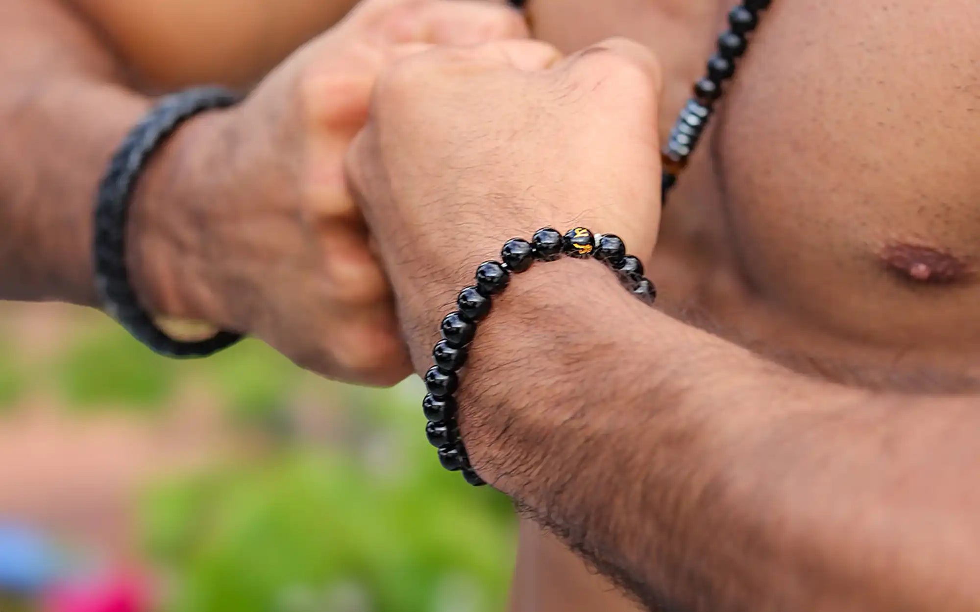 Black beaded bracelet worn on a wrist.