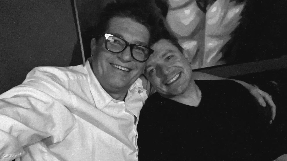 Black and white selfie of two friends smiling together.