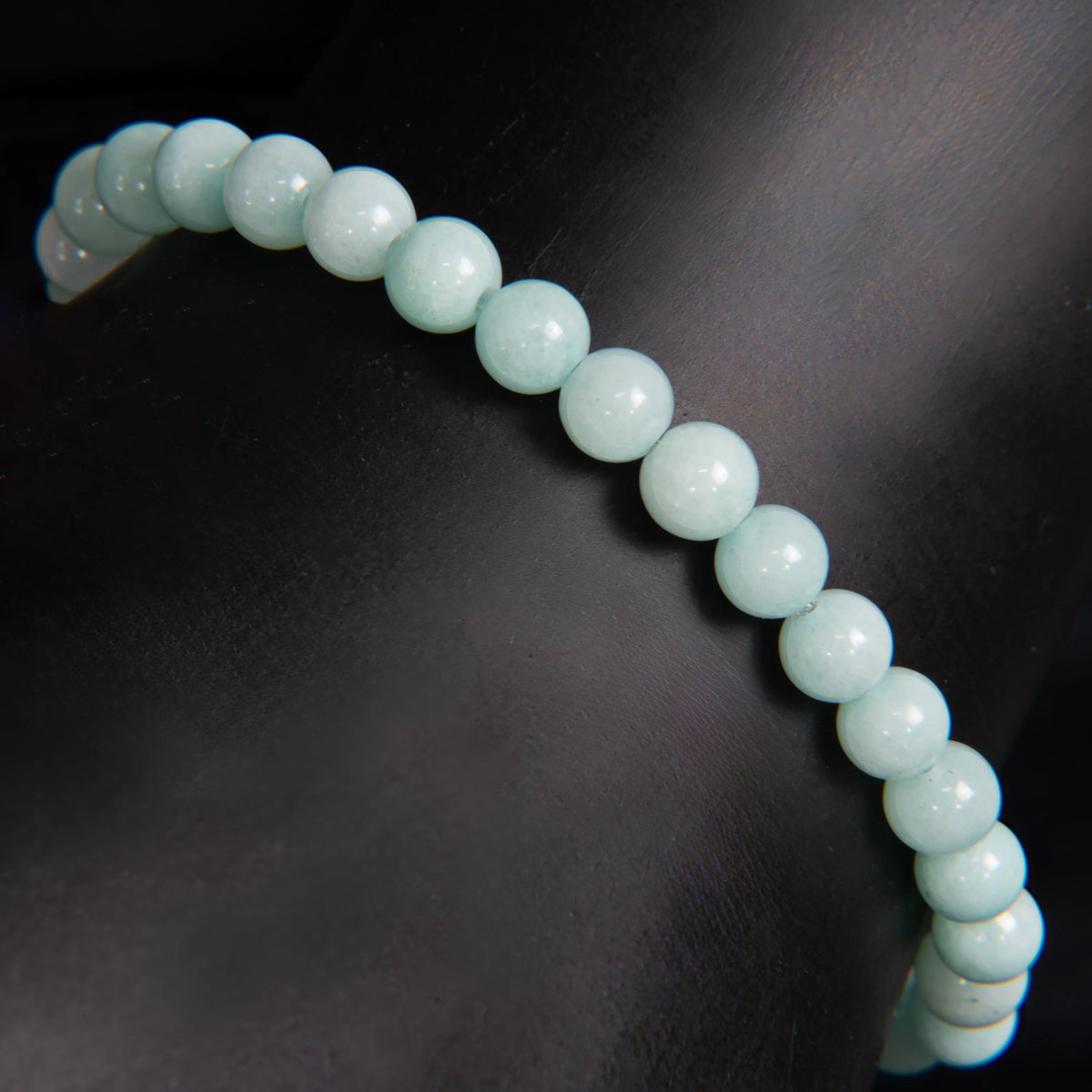 String of pale blue-green spherical beads forming a curved line.