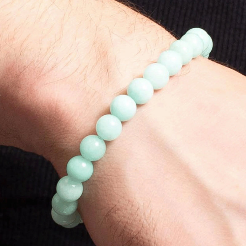 Pale mint green beaded bracelet worn on a wrist.