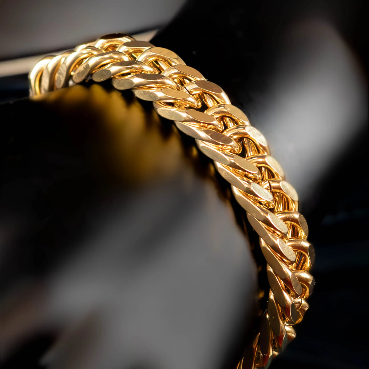 Gold chain bracelet with interlocking links in a twisted rope pattern.