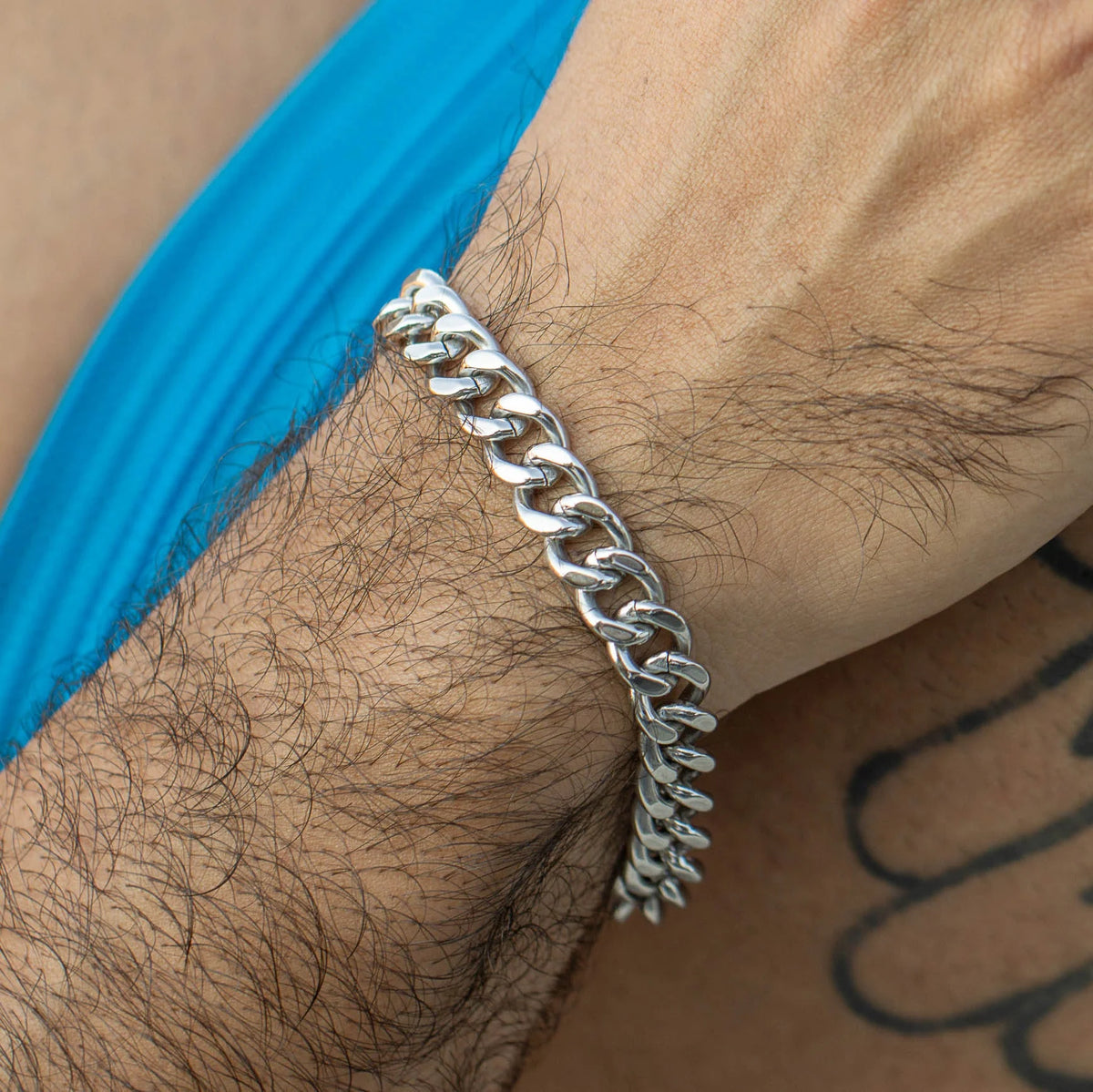 Silver chain-link bracelet worn on a wrist.