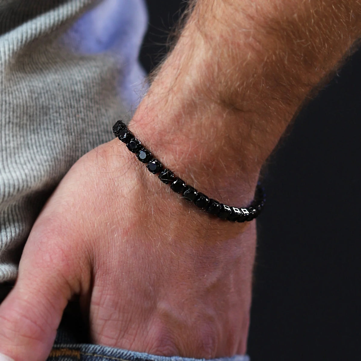 Black beaded bracelet worn on a wrist.