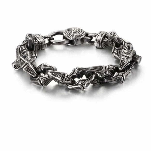 Ornate silver bracelet with intricately designed links and a circular clasp.