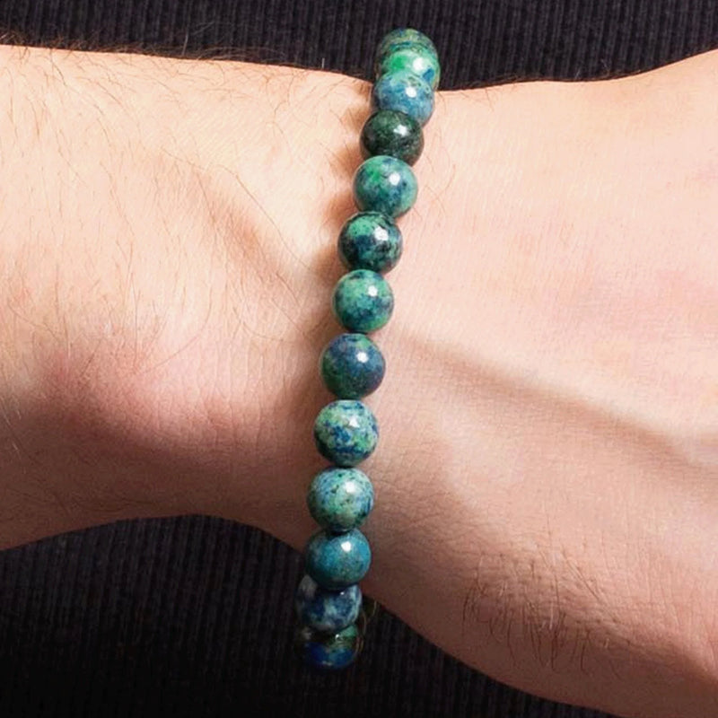 Green and blue speckled stone bead bracelet worn on a wrist.