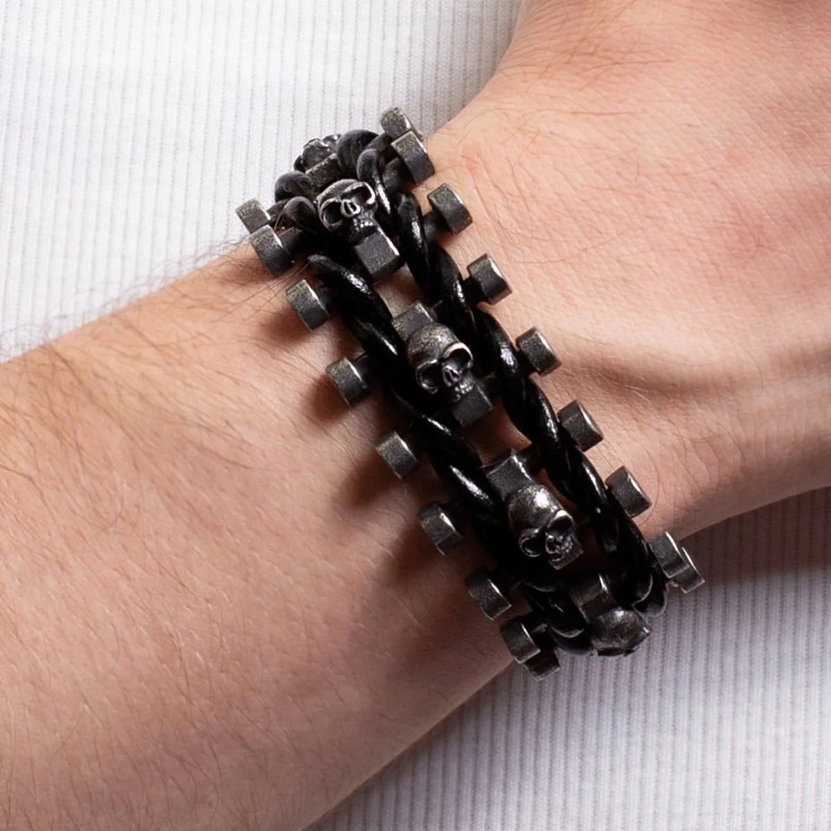 Black leather bracelet with metal skull beads and studs worn on a wrist.