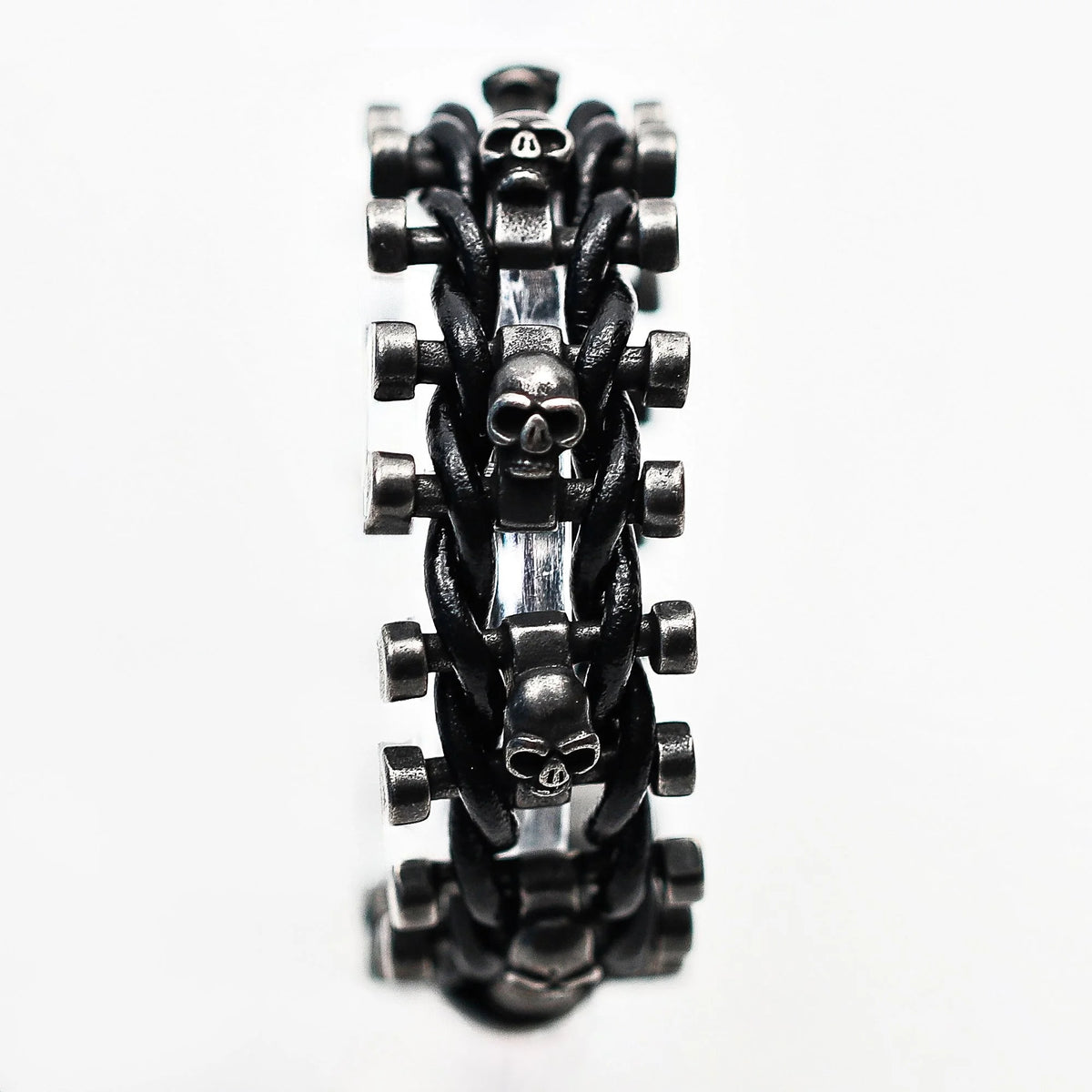 Black metal bracelet with skull designs and interwoven links.