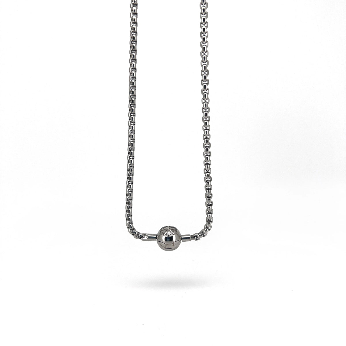 Silver chain necklace with a small spherical pendant.