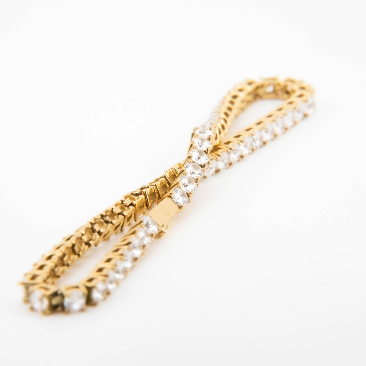 Gold bracelet with diamond accents arranged in a bow design.