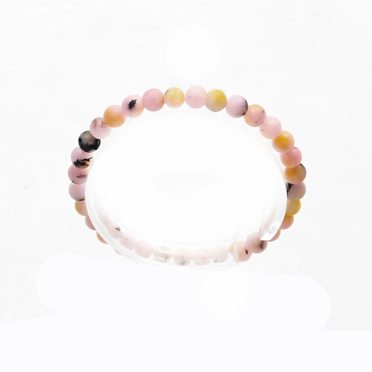 Beaded bracelet with pastel pink, yellow, and dark-speckled round stones.