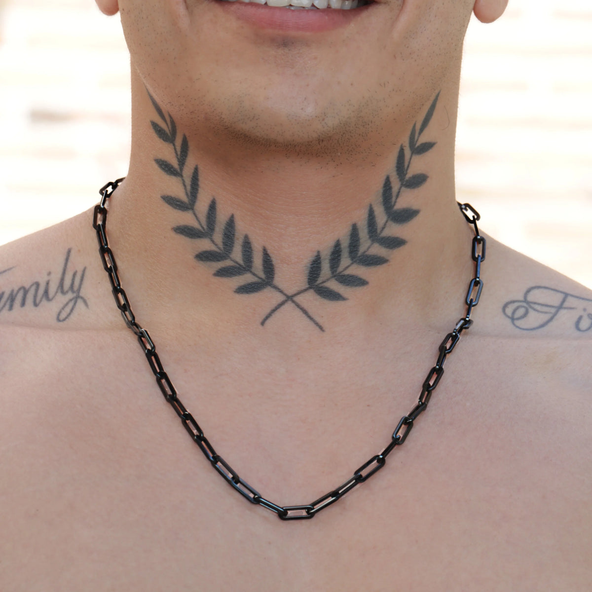 Tattoo of crossed olive branches on a neck.