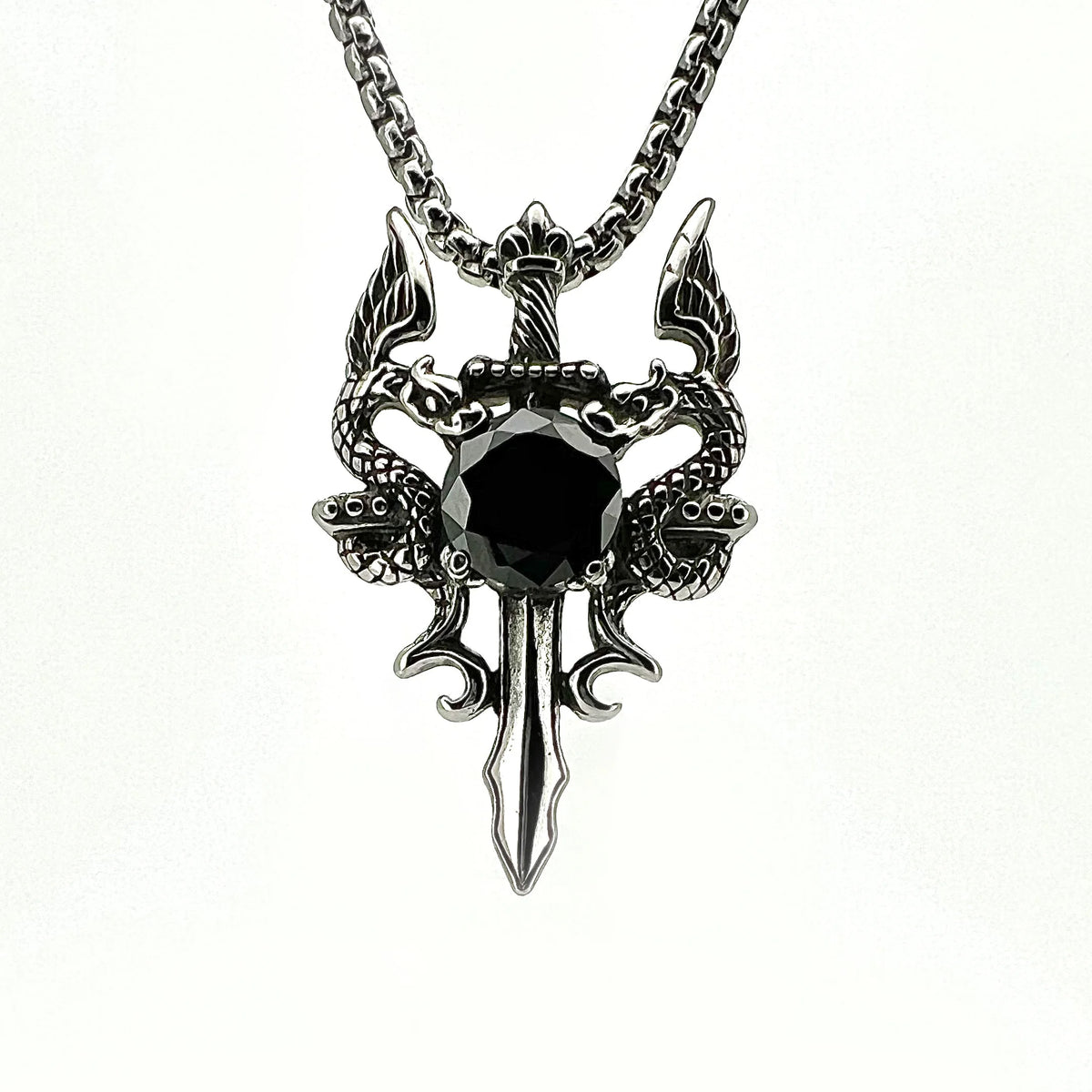 Intricate silver pendant featuring a dragon-like design with a black gemstone centerpiece.