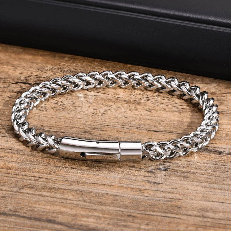 Silver chain bracelet with a cylindrical clasp.