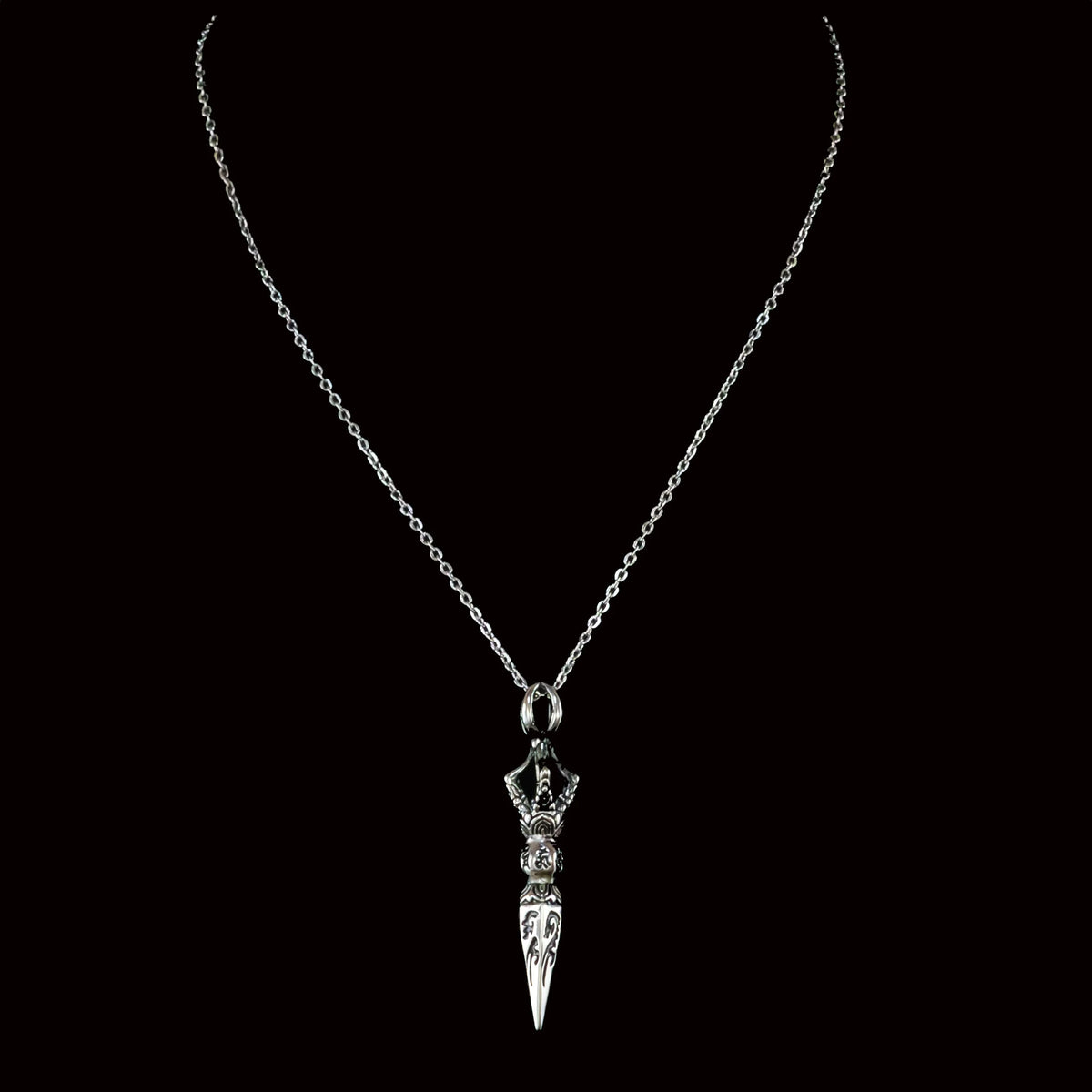 Silver necklace with an ornate dagger-shaped pendant.