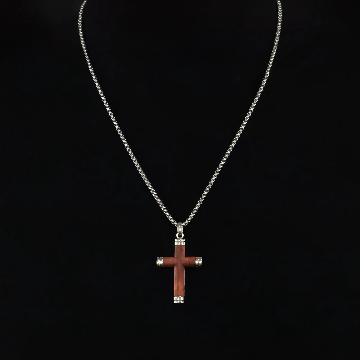 Silver necklace with a wooden cross pendant.