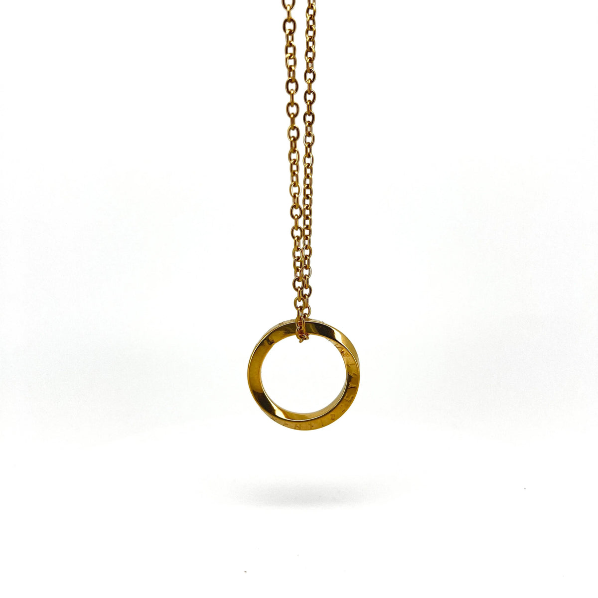 Gold circular pendant hanging from a delicate chain necklace.