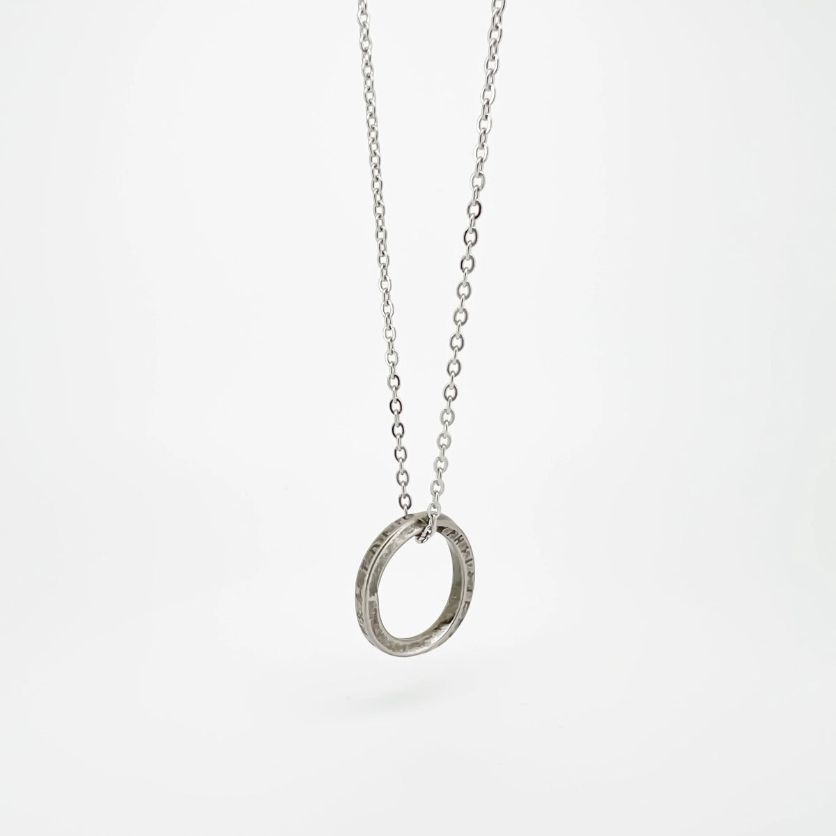 Silver ring pendant on a delicate chain necklace.