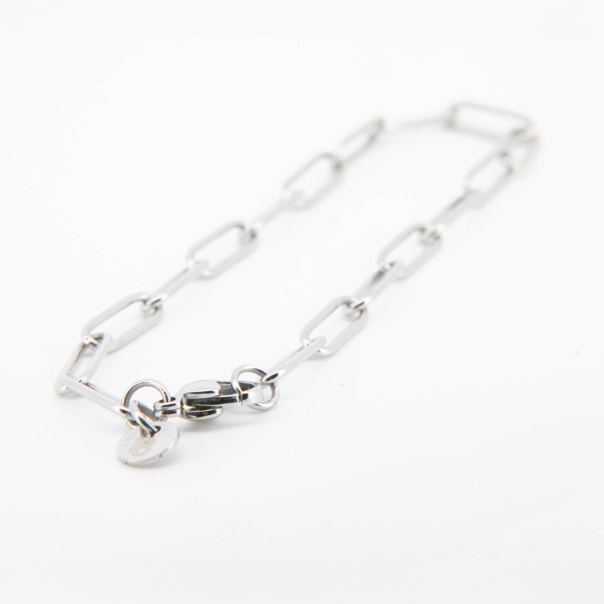 Silver chain bracelet with elongated oval links and a heart charm.