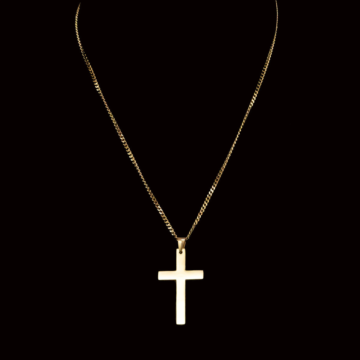 Gold cross pendant on a delicate chain necklace.