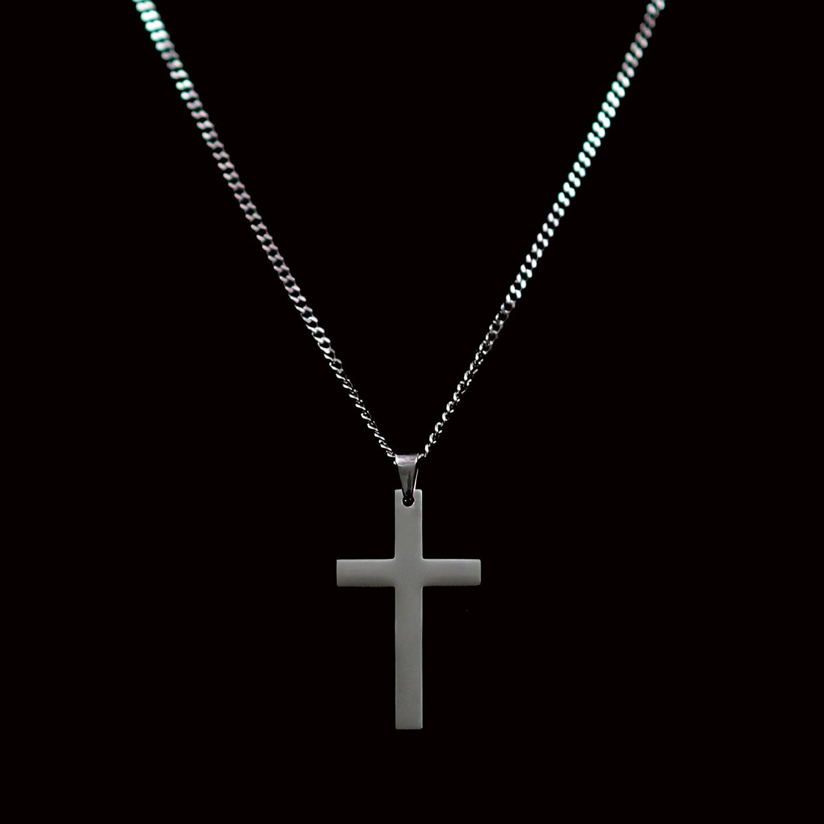 Silver cross pendant on a chain necklace.