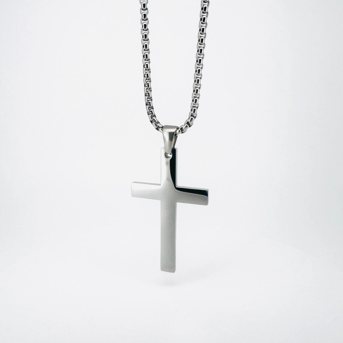 Silver cross pendant on a chain necklace.