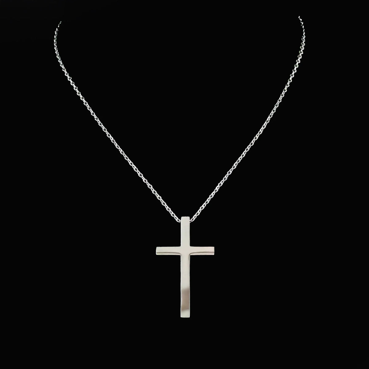 Silver cross pendant on a delicate chain necklace.